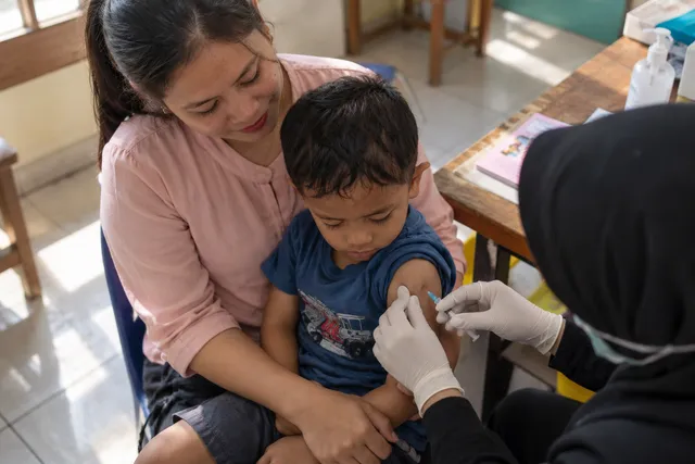 A health worker helps a mother with her baby