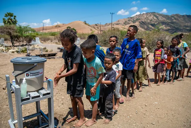 Children line up cheerfully to wash their hands at a Danantara aid handwashing station in NTT